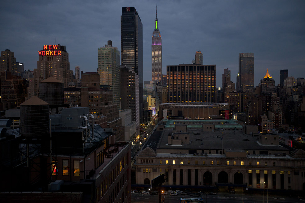the empire state building center is lit up with rainbow flood lights ...